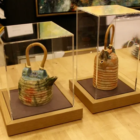 Urna transparente de metacrilato protegiendo una obra expositiva